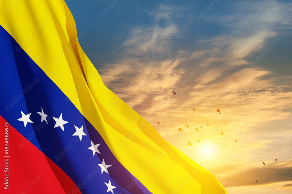 Obraz premium Venezuela flag on background of sunset sky with flying birds. Patriotic concept. Banner with place for text.