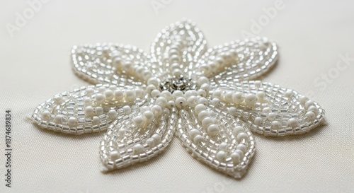 Detailed macro photograph showing sparkling white beads sewn onto soft ivory material creating a delicate abstract or floral pattern for luxury design, cream, lace, abstract