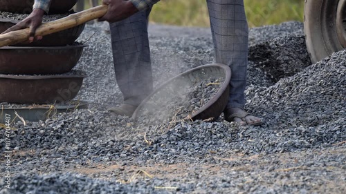 Indian labor working with gravel and stone at construction site. 