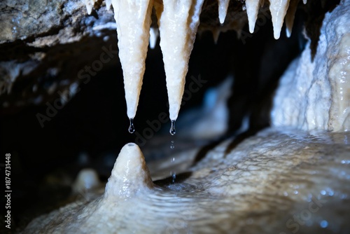 Stalactites and stalagmites in a cave with water droplets falling