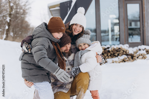 Canvas-taulu Happy family hugging in snow during winter vacation