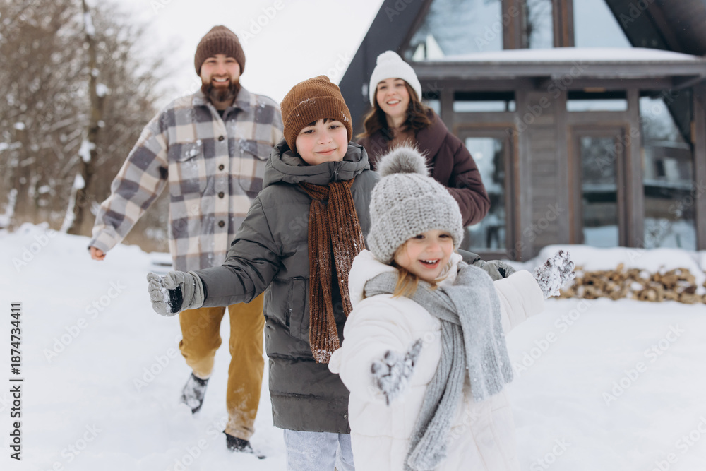 Obraz premium Happy family playing together enjoying winter vacation