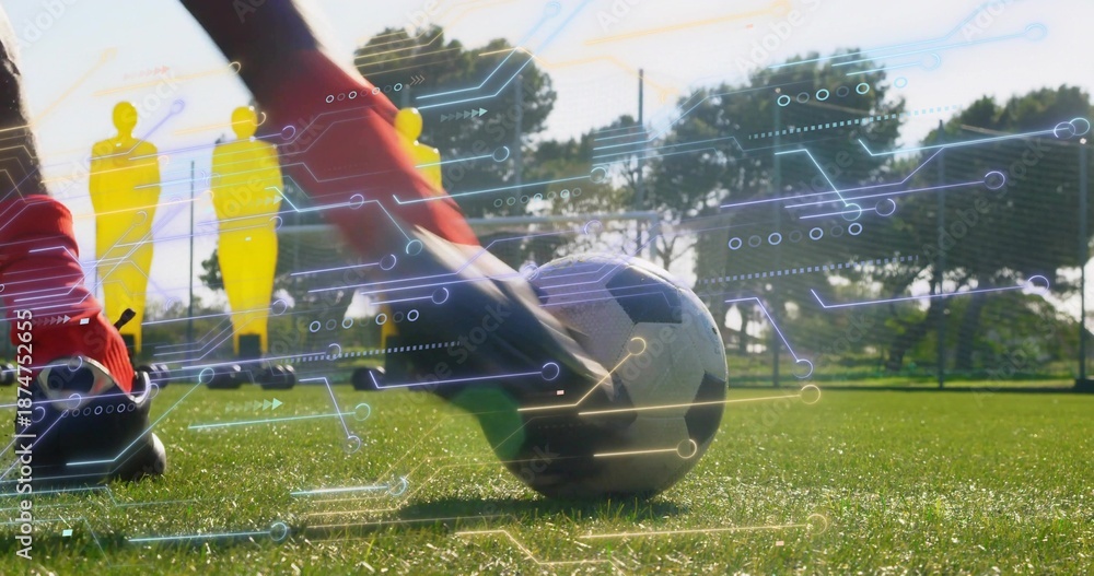 Naklejka premium Striking player feet in red socks contacting soccer ball on turf, mannequins and overlay