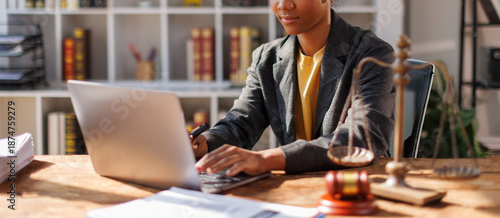 Billede på lærred A woman in afro hair paralegal immersed in work at a law office, surrounded by paperwork and legal documents