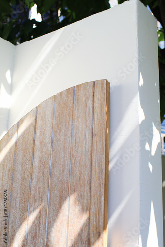 Wooden curve door bath with sunlight. Modern minimal exterior design. Outdoor garden. Cozy summer background