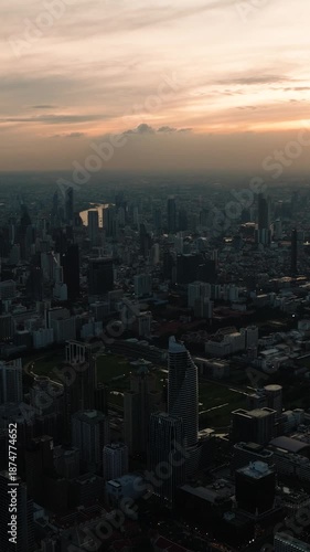 Twilight view of Bangkok city skyline with glowing lights from high rise buildings and fading sunlight. Bangkok, Thailand.
