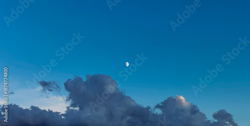 Luna di giorno nel cielo sopra le nuvole