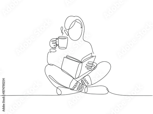 A woman sits cross-legged on the floor, reading a book and enjoying a cup of coffee in a peaceful atmosphere.