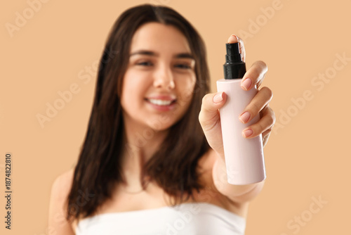 Young woman with hair spray...