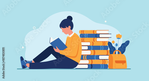 Young woman sitting on the floor and reading a book next to a very tall stack of colorful hardcover books.