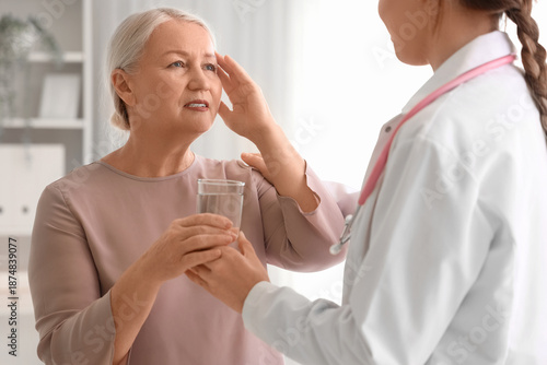 Mature woman taking glass o...