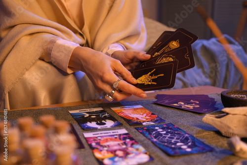 Fotografie Fortune teller reading tarot cards at table in room, closeup