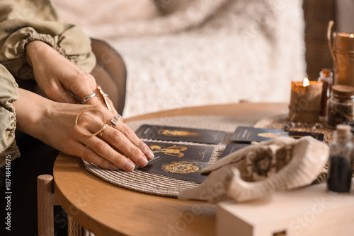 Tableau sur toile Female fortune teller reading tarot cards at table in room