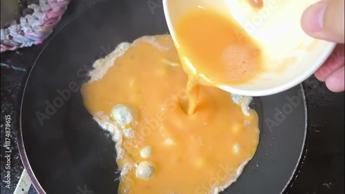 Frying eggs in pan, indoor Chiangmai Thailand.