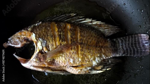 Frying sun-dried fish in pan, indoor Chiangmai Thailand.