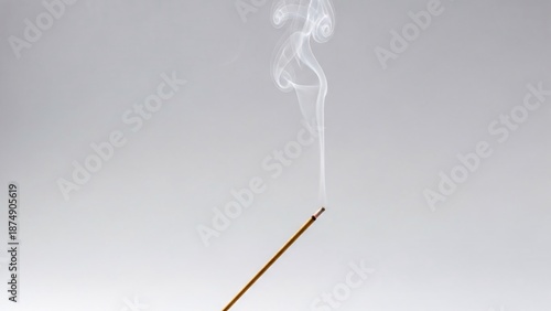 Incense stick burning with wisps of smoke against a clean white background