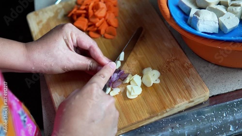 Hands Cutting Fresh Garlic for Cooking in Home Kitchen