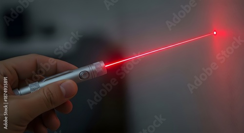Hand holding a laser pointer emitting a red beam of light.