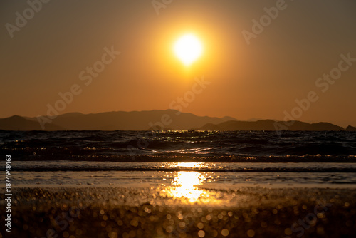 海岸の砂浜に沈む夕日