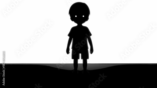 Silhouette of a young boy standing alone in darkness