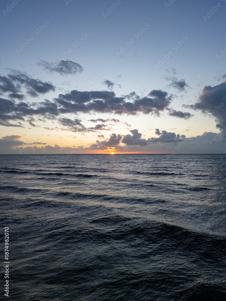 Obraz premium Capture the stunning and beautiful beauty of a breathtaking sunset reflecting on calm and tranquil ocean waters