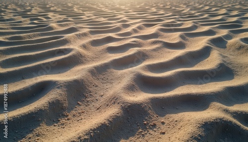 Close Up Of Rippled Sand Dunes With Golden Sunlight Casting Long Shadows Across The Texture In A Warm Desert Landscape