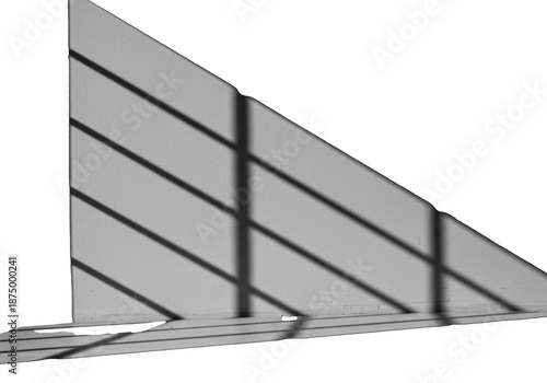 High-contrast monochromatic close-up of sharp, directional sunlight casting soft, blurred, geometric shadows onto a polished gray concrete wall, study in minimalist architecture and chiaroscuro