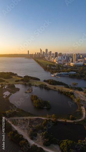 Aerial view of Perth city skyline with Boorloo bridge lit up connecting Heirisson island with walking and cycling path along the Swan river