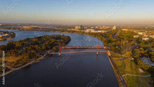 Aerial view of Perth city skyline with Boorloo bridge lit up connecting Heirisson island with walking and cycling path along the Swan river