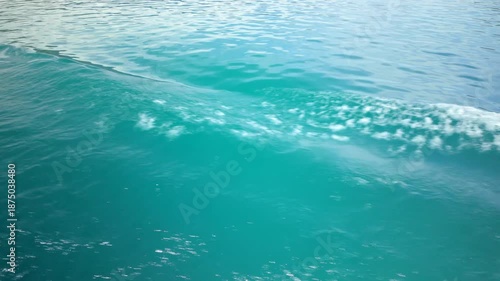 Turquoise lake water with boat wake and bubbles