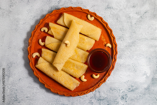 Canvas Print Patishapta Pitha, a Traditional Bengali dessert featuring thin rice flour crepes filled with sweet coconut, jaggery, or khoya, gently folded and served warm during festivals, celebrations, winter