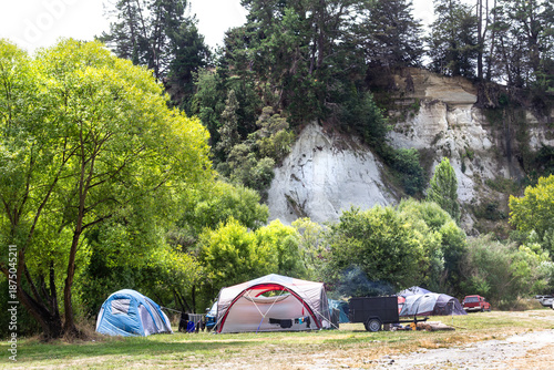 New Zealand summer camping. Tents at Vinegar Hill Campground, in canyon below Rangitīkei River clay papa cliffs, at Putai Ngahere Domain, Manawatū-Whanganui region. 