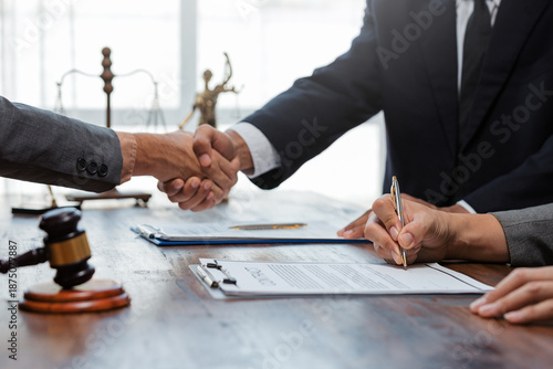 Photos Legal professionals completing a deal, clients signing documents with a lawyer n