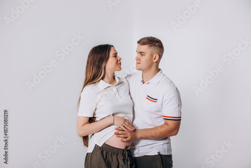 Bild auf Leinwand A married couple - a man and a pregnant woman together in the studio, beautiful