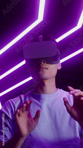 Man in virtual reality headset playing online video game in VR studio