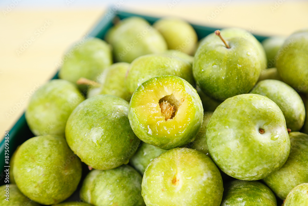 Obraz premium Fresh Green Sichuan Plums - Crisp Healthy Fruits in Container