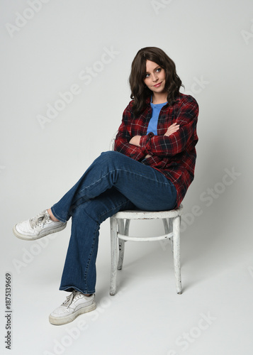 Bild auf Leinwand Full length portrait pretty young brunette female model wearing casual modern plaid  flannel shirt and jeans, sneakers