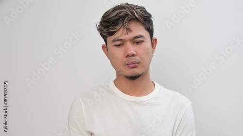 Video portrait of an Asian adult man shaking head with serious expression. Disagreement, rejection, refusal and negative response concept in everyday lifestyle.