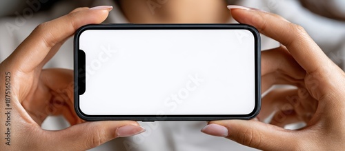 Hands holding a smartphone horizontally with a blank white screen.