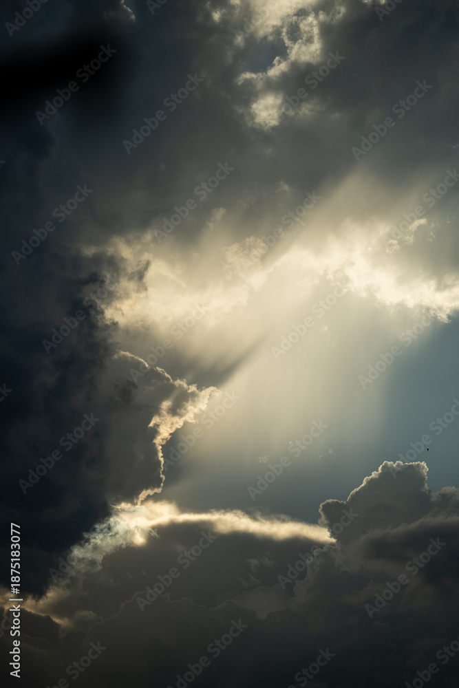 Obraz premium Celestial Radiance: Sunbeams Breaking Through Storm Clouds