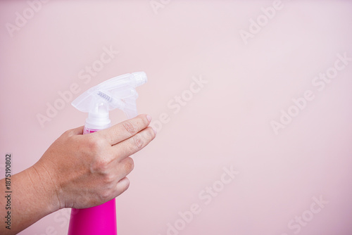 The hand holding the spray bottle.