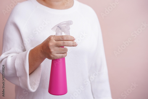 The hand holding the spray bottle.