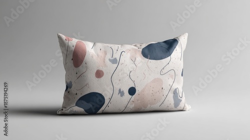 Abstract patterned pillow with soft pastel colors on a neutral background