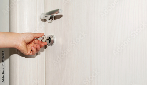 Close-up of hand using key in door lock