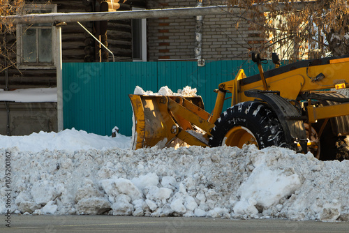 Heavy Yellow Front-End Loader Pushing Snow on City Street