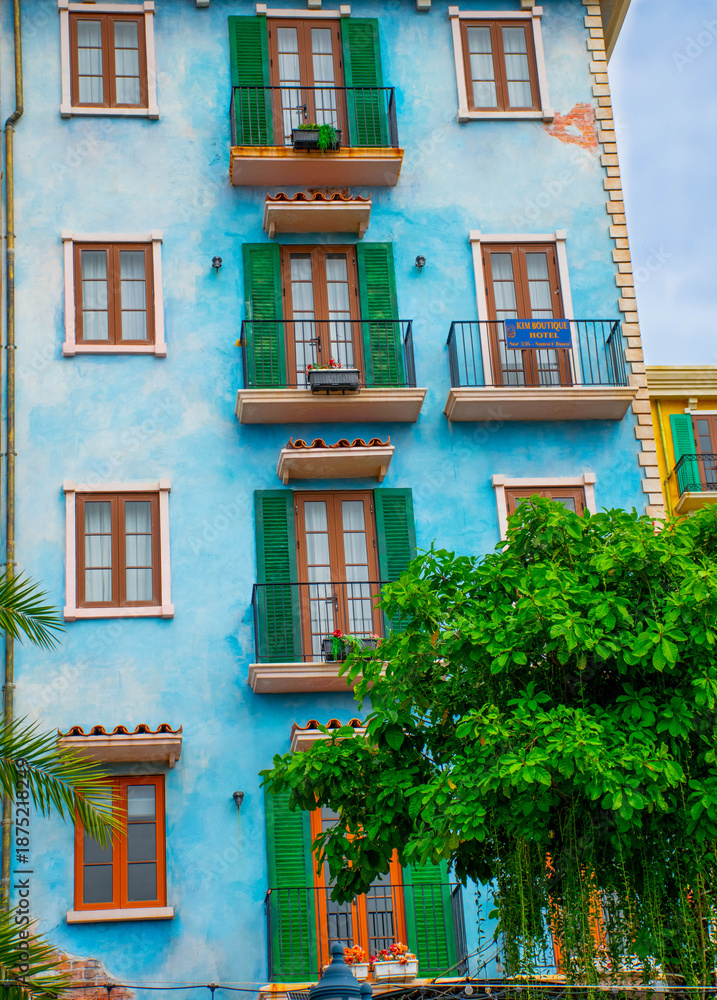 Naklejka premium colorful residential buildings with balconies and palm trees, reflecting mediterranean architecture and vibrant urban lifestyle.