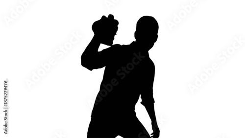 Man silhouette poised for a powerful throw or strike in a bold and dramatic pose