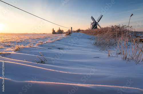 Winter sunrise at a windmill in the Dutch countryside.