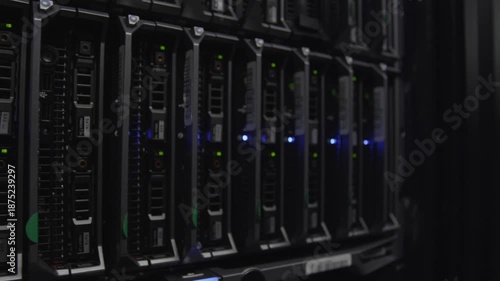 Close-up view of computer servers with blue and green lights in a dark room.
