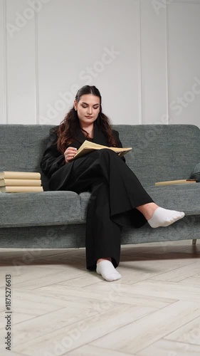 Businessman studies among books corporate specialist is immersed in reading in office. Woman carefully studies materials while sitting on sofa in organized workspace, specialist is focused on research